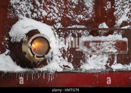 Frontansicht Details von einem roten alten Zug Lok umfaßt im Schnee, Frost und Eiszapfen im Bahnhof, Winterzeit Stockfoto