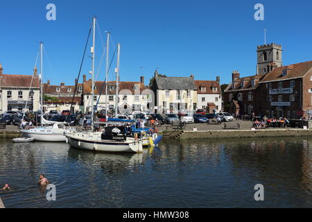 Wareham Quay und Old Granary mit festsitzenden Yachten, sonniger Tag mit Kindern im Wasser. River Frome an heißen Sommertagen. Urlaubsaufenthalt Sonntagsausflug Stockfoto