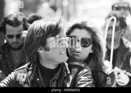 Peter Fonda und Nancy Sinatra am Set von 1966 Roger Corman Film, "The Wild Angels". Sichtbar sind auch Mitglieder der Hells Angels Motorrad-Gang. Die Stadt ist unbekannt, aber es ist wahrscheinlich Venedig Kalifornien. Stockfoto