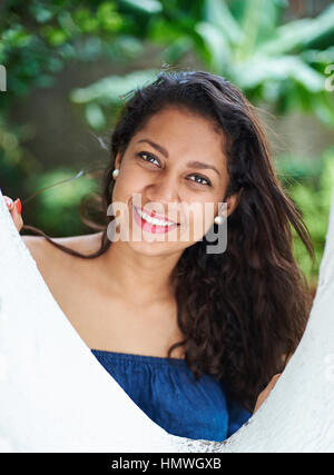 Glücklich lächelnd junges Mädchen im grünen Park neben dem Baum Stockfoto