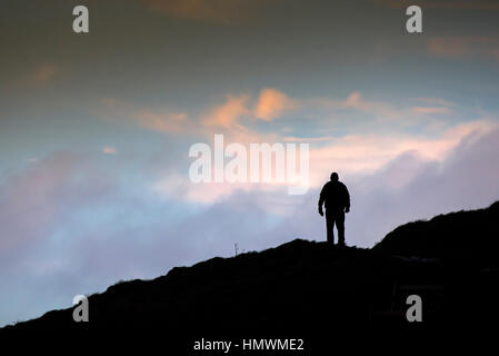 Die Silhouette eines Mannes zu Fuß über Towan Landzunge in Newquay, Cornwall. Stockfoto