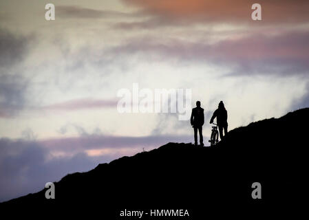 Zwei Männer in der Silhouette zu sehen, wie sie über Towan Landzunge in Newquay, Cornwall gehen. Stockfoto