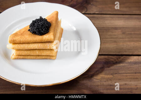 traditionelle russische Pfannkuchen auf Teller mit schwarzem Kaviar Stockfoto