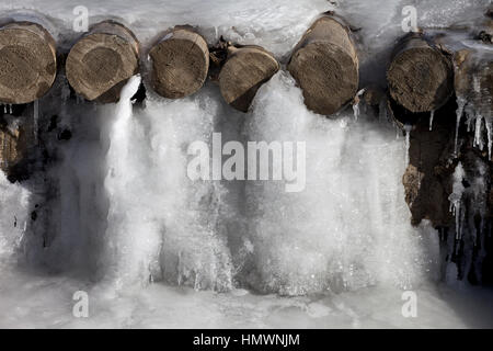 Eisigen Gebirgsbach und Holzbrücke in Eis eingefroren. Winter in den Karpaten, Ukraine. Stockfoto
