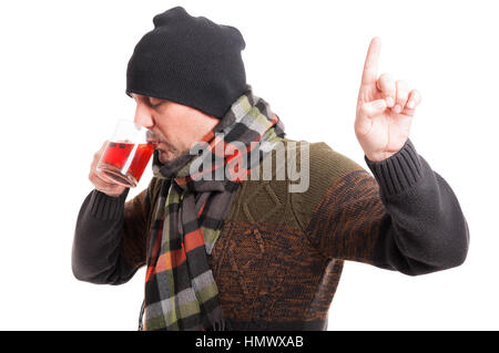 Kranker Mann mit Grippe heißen Tee trinken und warten Geste auf weißem Hintergrund zu tun Stockfoto