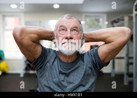 Passen Sie senior woman im Fitness-Studio arbeiten seine Bauchmuskeln Crunches zu tun. Stockfoto