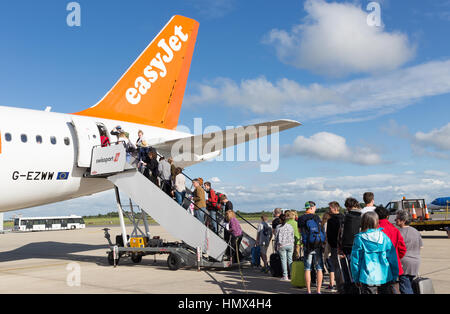 BRISTOL, UK - 11. Juli 2016: Eine Warteschlange von Fluggästen das Endstückende des Flugzeuges Easyjet am Flughafen Bristol an einem sonnigen Tag. Stockfoto