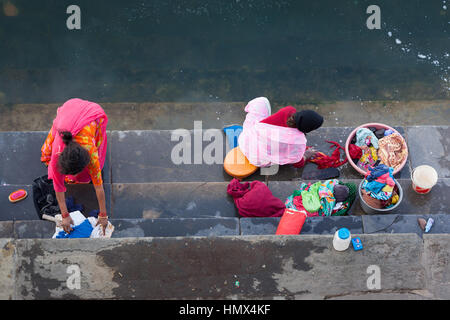 UDAIPUR, Indien - 16. Januar 2015: Luftaufnahme von zwei Frauen, die Wäsche auf den Stufen des Lal Ghat neben Pichola-See. Stockfoto