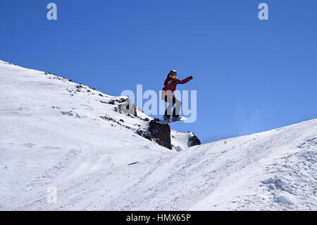 Snowboarder springen im Snowpark im Skigebiet auf Sonne Wintertag. Kaukasus-Gebirge, Region Dombay. Stockfoto