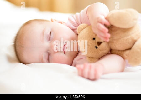 Säugling Baby schläft mit Plüsch-Spielzeug Stockfoto
