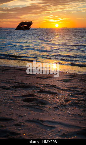 Kap kann mit dem Schiffbruch bei Sonnenuntergang am Strand. Stockfoto