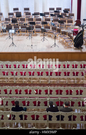 Leeren Zuschauerraum und die Bühne vor dem Konzert. Auf der Bühne steht Musik mit Noten, Bandura und Trommel. In der Halle 3 Männer Stockfoto