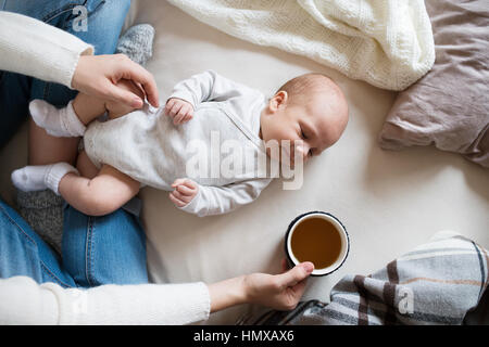 Nicht erkennbare Mutter mit Neugeborenen Sohn auf Bett liegend Stockfoto