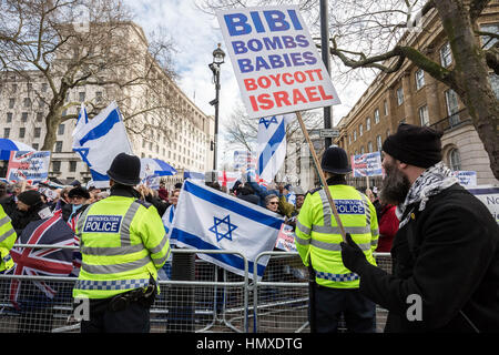 London, UK. 6. Februar 2017. Pro-palästinensische Anhänger mit Plakat geht es vorbei an pro-israelischen Fans wehende Fahnen am Tag des israelischen Ministerpräsidenten, Benjamin Netanyahu Besuch in Downing Street. Guy Corbishley/Alamy Live-Nachrichten Stockfoto