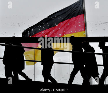 Berlin, Deutschland. 7. Februar 2017. Eine Nationalflagge weht im Wind auf dem Dach der Reichtstag, während Besucher der Galerie in Berlin, Deutschland, 7. Februar 2017 entlang. Foto: Paul Zinken/Dpa/Alamy Live News Stockfoto