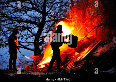 Stapel von Holz und Zungen aus Feuer in indoor gemauerten Kamin im