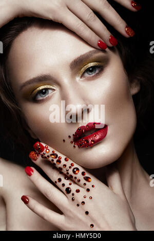 Schöne Mädchen mit Abend Make-up, rote Lippen in Strass und design Maniküre Nägel. Schönheit Gesicht. Stockfoto