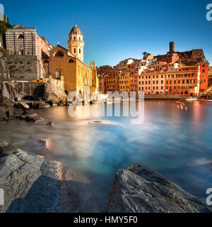 Vernazza Dorf, Kirche, Felsen und Meer Hafen bei Sonnenuntergang, Seelandschaft in Cinque Terre Nationalpark Cinque Terre, Ligurien Italien Europa. Langzeitbelichtung. Stockfoto