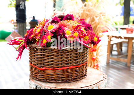 Eine Reihe von verschiedenen Farben in einem hölzernen Korb. Blumen in einem Weidenkorb. Stockfoto