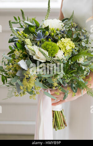 Brautstrauß in der Hand der Braut an ihrem Hochzeitstag. Stockfoto