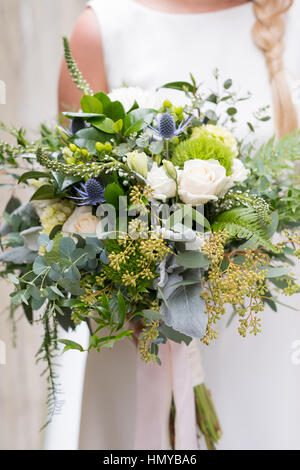 Brautstrauß in der Hand der Braut an ihrem Hochzeitstag. Stockfoto
