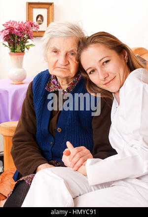 Junger Arzt hält die alte Hände Stockfoto