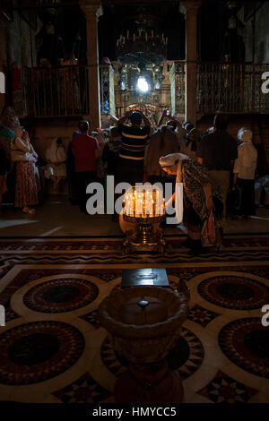 Jerusalem, Israel - 1. Juni 2014: Eine Frau, die von dem Omphalos, die Mitte der Welt in der Griechischen Kapelle namens catholicon während griechische Nacht Masse in der ch Stockfoto