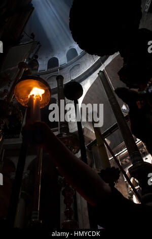 Jerusalem, Israel - 30. Mai 2014: Pilgrim leuchtet eine Kerze vor dem Eingang aedicula, geglaubt das Grab von Christus zu sein. Aedicula ist Stockfoto
