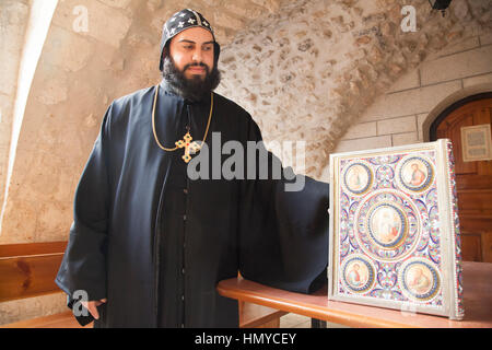 Jerusalem, Israel - 26. November 2013: syrisch-orthodoxe Priester mit syrischen Bibel in ihrer Patriarchat in Jerusalem. Stockfoto