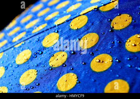 Regentropfen auf einen bunten Regenschirm. Stockfoto