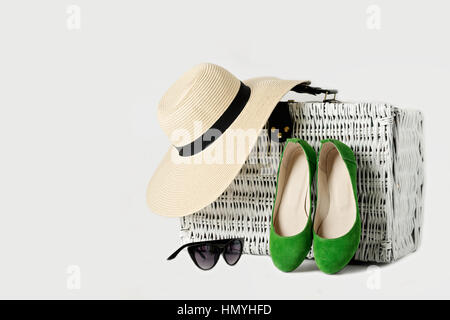 Weißen geflochtenen Koffer, Damen Hut, Sonnenbrille und grüne Schuhe. Selektiven Fokus. Stockfoto