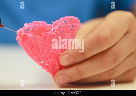 Kinder Hand halten Herz, das mit 3D Stift gemacht wird. Ansicht von oben. Platz für Text zu kopieren. Selektiven Fokus Stockfoto