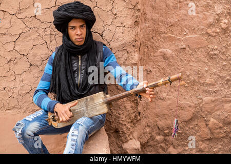 Marokko.  Teenager Amazigh Berber Musiker spielt ein Gimbrie.  Ait Benhaddou Ksar, ein UNESCO-Welterbe. Stockfoto