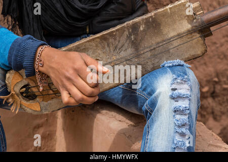 Marokko.  Teenager Amazigh Berber Musiker spielt ein Gimbrie.  Ait Benhaddou Ksar, ein UNESCO-Welterbe. Stockfoto