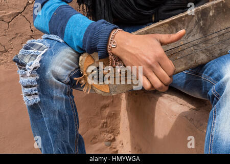 Marokko.  Teenager Amazigh Berber Musiker spielt ein Gimbrie.  Ait Benhaddou Ksar, ein UNESCO-Welterbe. Stockfoto