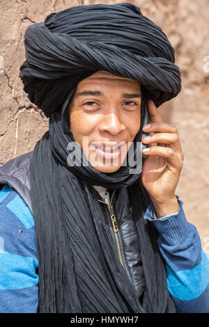 Marokko.  Teenager Amazigh Berber junge Mann reden auf seinem Handy, Ksar Ait Benhaddou, ein UNESCO-Welterbe. Stockfoto