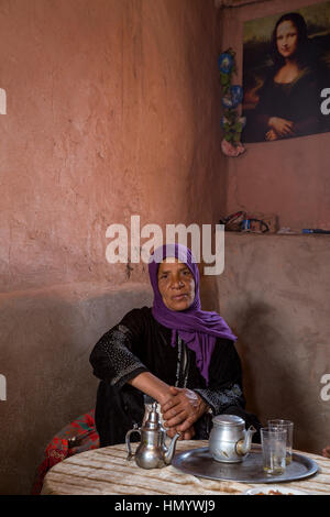 Marokko.  Amazigh Berber Frau in ihrem Hause sitzen unter Mona Lisa, Ksar Ait Benhaddou, ein UNESCO-Welterbe. Stockfoto