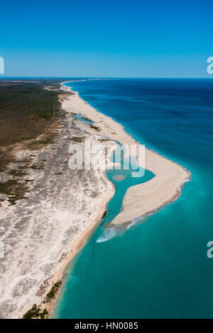 Eine unbewohnte endlosen weißen Sandstrand entlang einem türkisfarbenen Meer. Stockfoto