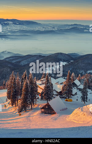 Verschneite Postavaru Chalet in der warmen Abendlicht auf 1604m Höhe im Postavaru Gebirge, Resort in Poiana Brasov, Rumänien Stockfoto