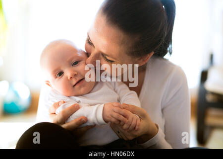 Schöne Mutter hält ihr niedlichen Baby-Sohn Stockfoto