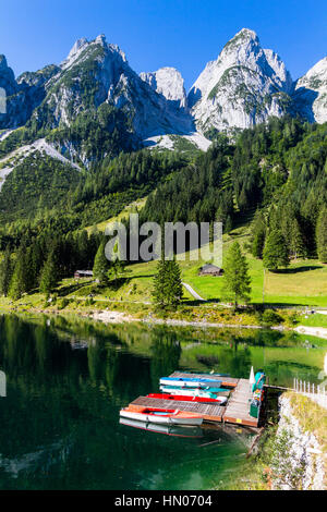 Schöne Aussicht auf die idyllische bunte Sommerlandschaft klar Gosausee Bergsee mit bunten Booten, Salzkammergut region Stockfoto