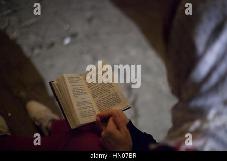 Jerusalem, Israel - 17. November 2013: Ein Pilger liest eine Bibel in der Heilig-Grab-Kirche in Jerusalem. Stockfoto