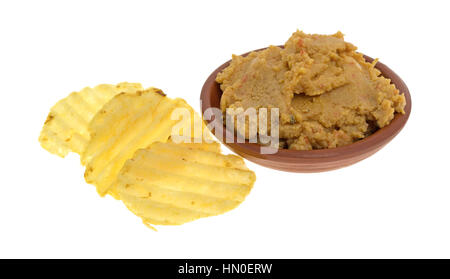 Eine kleine Schüssel mit Hummus-Artischocken-Dip mit Kartoffel-Chips auf der Seite isoliert auf einem weißen Hintergrund. Stockfoto