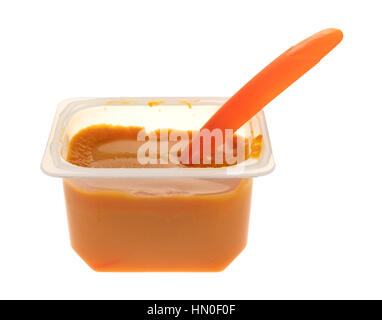 Eine Portion von Banane Karotte und Mango Babynahrung in einem Plastikbehälter mit orange Löffel isoliert auf einem weißen Hintergrund. Stockfoto