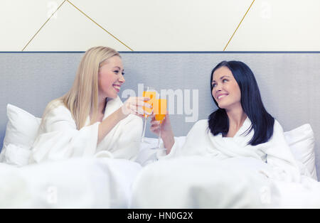 lächelnden Freundinnen frühstücken im Bett Stockfoto