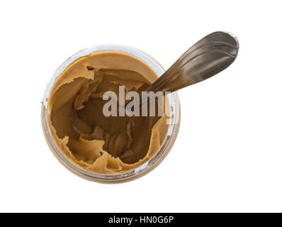 Draufsicht auf eine geöffnete Glas cremige Erdnussbutter mit einem Löffel in die Speisen auf einem weißen Hintergrund isoliert. Stockfoto