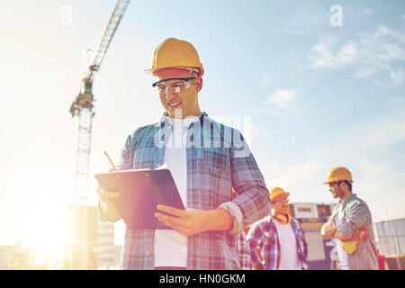 Baumeister in Bauarbeiterhelm mit Zwischenablage am Bau Stockfoto