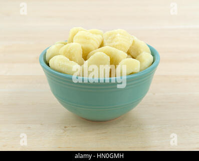 Einfache Kartoffel-Gnocchi in einer grünen Schale auf einem Holztisch. Stockfoto