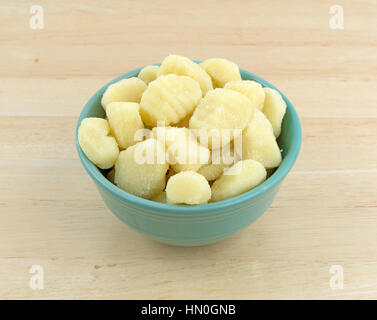 Einfache Kartoffel-Gnocchi in einer grünen Schale auf einem Holztisch. Stockfoto