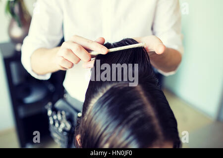 männlichen Stylistin Hände Kämmen der nassen Haare im salon Stockfoto
